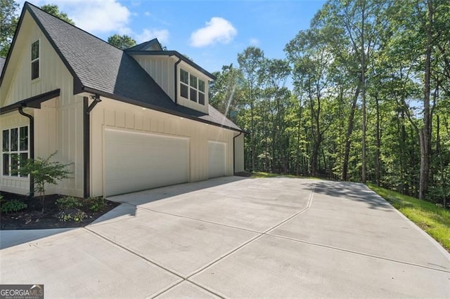 5567 Tyree Rd, Winston, GA 30187 - view of home's exterior with concrete driveway, a shingled roof, an attached garage, and board and batten siding