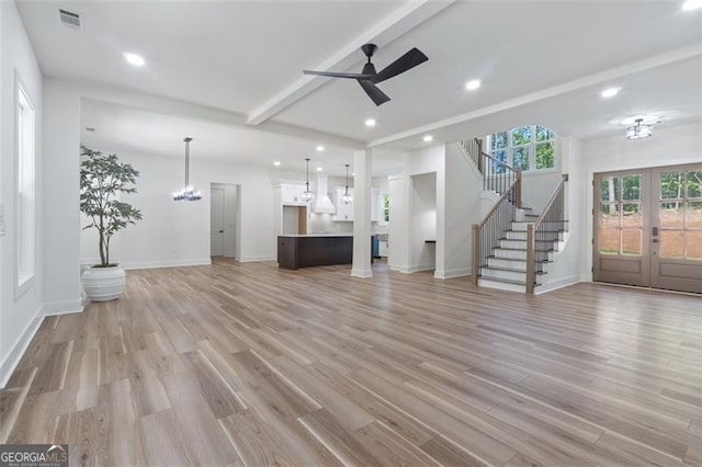 5567 Tyree Rd, Winston, GA 30187 - unfurnished living room featuring french doors, ceiling fan, light wood finished floors, a chandelier, and stairs