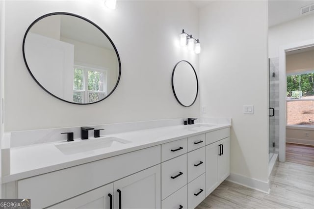 5567 Tyree Rd, Winston, GA 30187 - bathroom featuring double vanity, baseboards, a stall shower, and wood finished floors