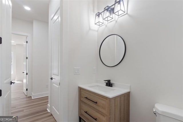 5567 Tyree Rd, Winston, GA 30187 - half bathroom featuring toilet, vanity, wood finished floors, baseboards, and recessed lighting