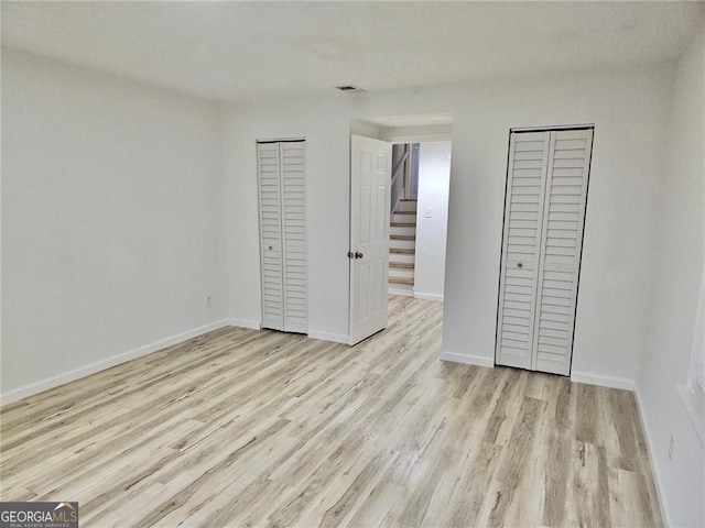 3045 Revere Cir, Snellville, GA 30039 - unfurnished bedroom featuring wood finished floors, two closets, and baseboards