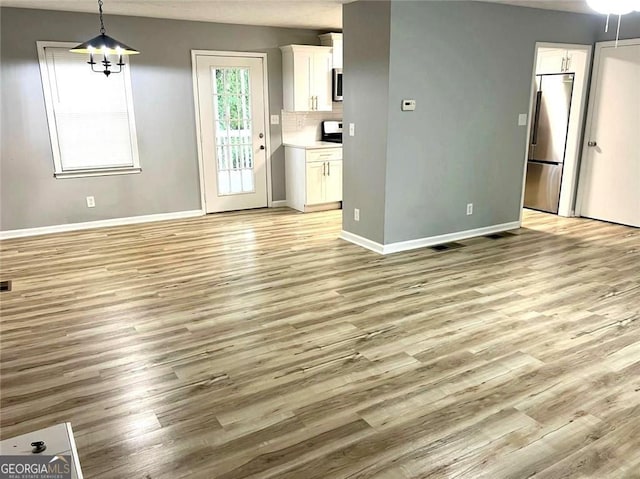 3045 Revere Cir, Snellville, GA 30039 - unfurnished living room with light wood-style floors and baseboards