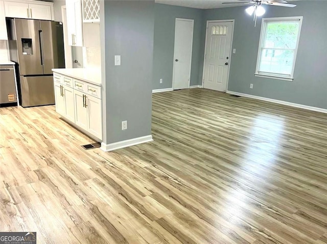 3045 Revere Cir, Snellville, GA 30039 - kitchen with stainless steel appliances, a ceiling fan, light wood-style floors, and baseboards