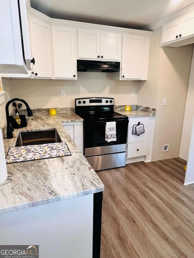 kitchen with stainless steel range with electric stovetop, under cabinet range hood, a sink, white cabinets, and light wood-type flooring