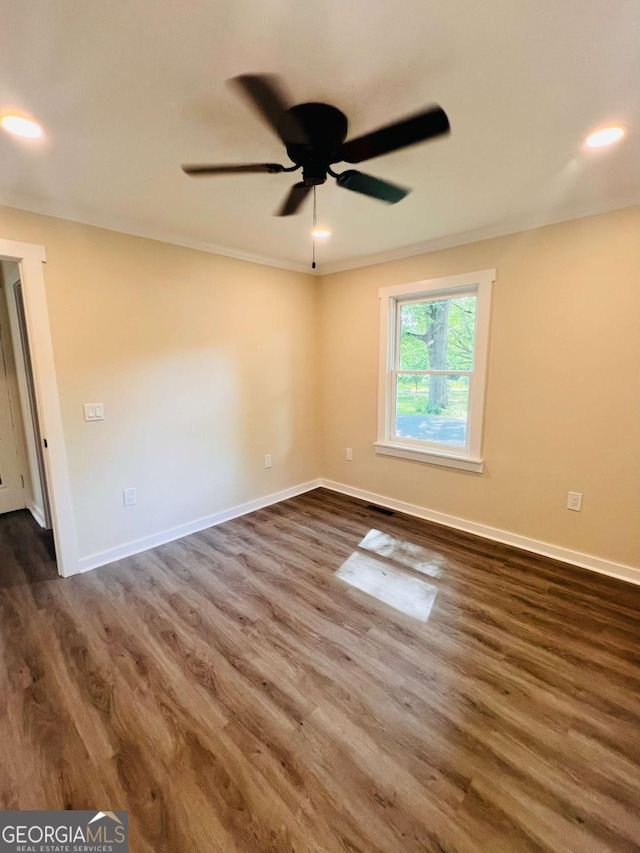 empty room with dark wood-style flooring, ceiling fan, baseboards, recessed lighting, and ornamental molding