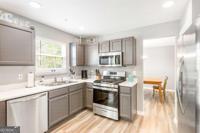 1194 Grandview Cir, Powder Springs, GA 30127 - kitchen with appliances with stainless steel finishes, a sink, gray cabinets, light wood-style flooring, and recessed lighting