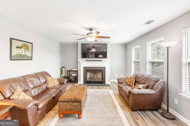1194 Grandview Cir, Powder Springs, GA 30127 - living room featuring wood finished floors, ceiling fan, a fireplace with flush hearth, and baseboards