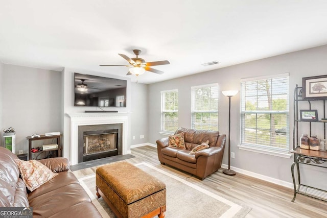 1194 Grandview Cir, Powder Springs, GA 30127 - living area featuring light wood-type flooring, a fireplace with flush hearth, a ceiling fan, and baseboards