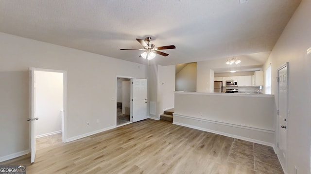 4162 Ward Lake Trl, Ellenwood, GA 30294 - unfurnished living room featuring light wood finished floors, baseboards, ceiling fan, and stairway