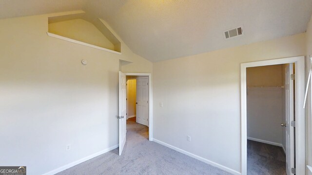 4162 Ward Lake Trl, Ellenwood, GA 30294 - unfurnished bedroom with carpet floors, a spacious closet, vaulted ceiling, baseboards, and a closet