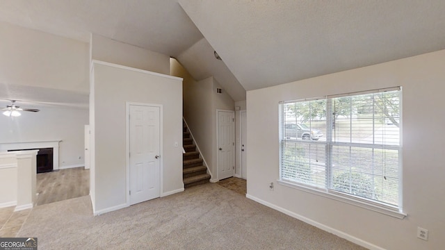 4162 Ward Lake Trl, Ellenwood, GA 30294 - unfurnished living room with ceiling fan, stairs, light carpet, vaulted ceiling, and a fireplace