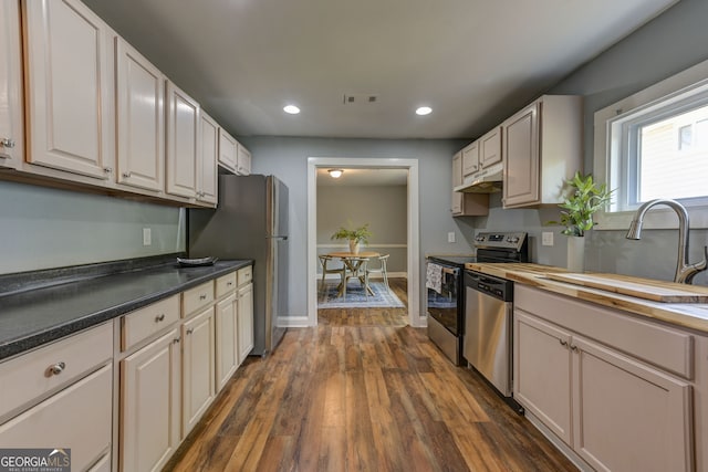103 Chicamauga Ave SW, Atlanta, GA 30314 - kitchen with appliances with stainless steel finishes, under cabinet range hood, a sink, dark wood-style floors, and recessed lighting