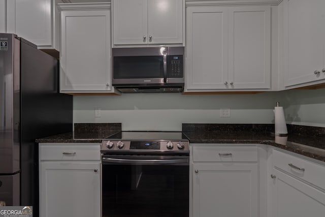 385 Orchard Land, Covington, GA 30014 - kitchen featuring appliances with stainless steel finishes, white cabinets, and dark stone counters