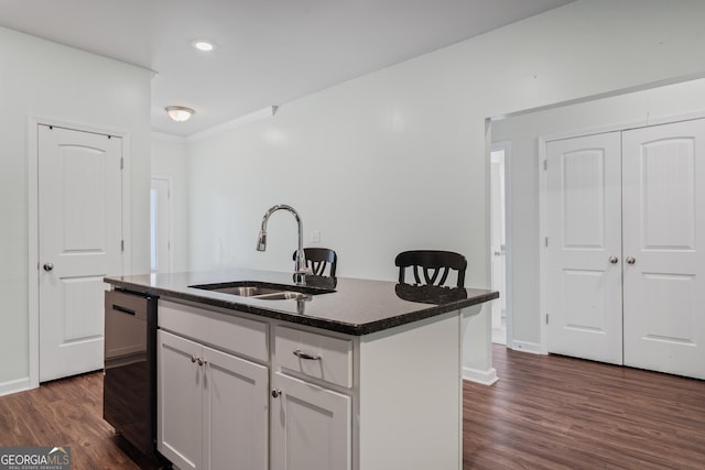 385 Orchard Land, Covington, GA 30014 - kitchen with a sink, dark countertops, dark wood-type flooring, white cabinets, and a kitchen island with sink