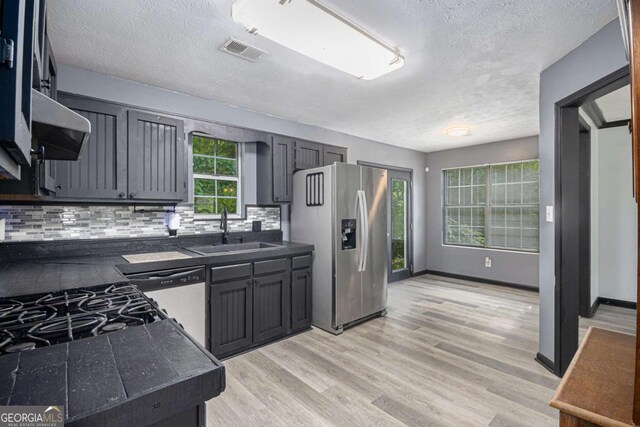 430 Pilgrim Ln, Powder Springs, GA 30127 - kitchen featuring stainless steel fridge with ice dispenser, a textured ceiling, light wood-type flooring, dishwashing machine, and tasteful backsplash