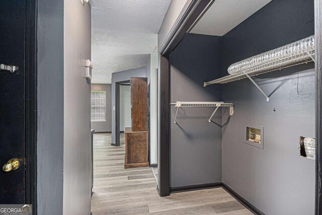 430 Pilgrim Ln, Powder Springs, GA 30127 - laundry room with washer hookup, light wood-style flooring, a textured ceiling, and baseboards