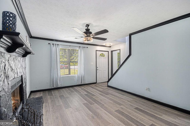 430 Pilgrim Ln, Powder Springs, GA 30127 - unfurnished living room featuring ceiling fan, wood finished floors, crown molding, a fireplace, and a textured ceiling