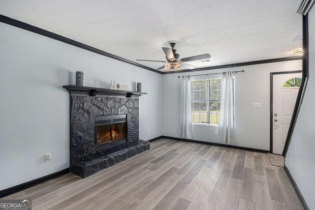 430 Pilgrim Ln, Powder Springs, GA 30127 - unfurnished living room featuring ceiling fan, ornamental molding, wood finished floors, a textured ceiling, and a stone fireplace