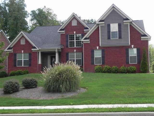view of front of house with a front lawn and brick siding