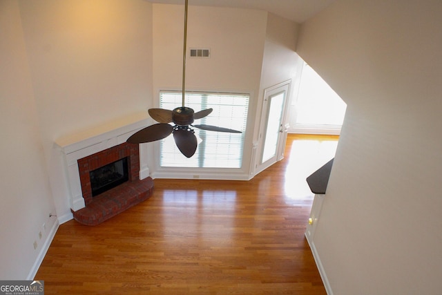 141 Windward Hls, Mcdonough, GA 30253 - unfurnished living room with wood finished floors, ceiling fan, baseboards, and a brick fireplace