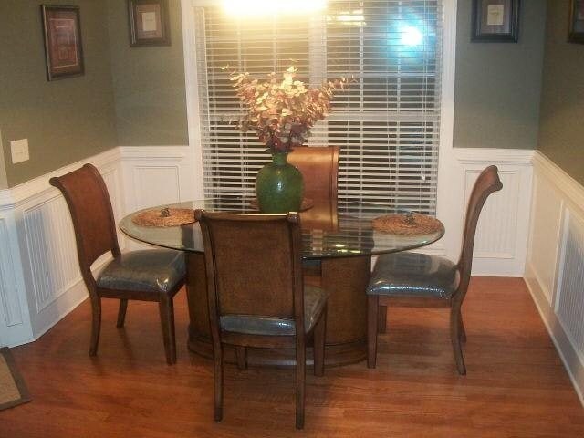 dining room featuring a decorative wall, wainscoting, and wood finished floors