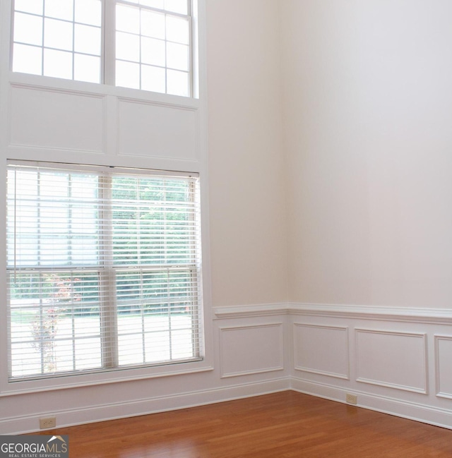 spare room featuring wainscoting and wood finished floors