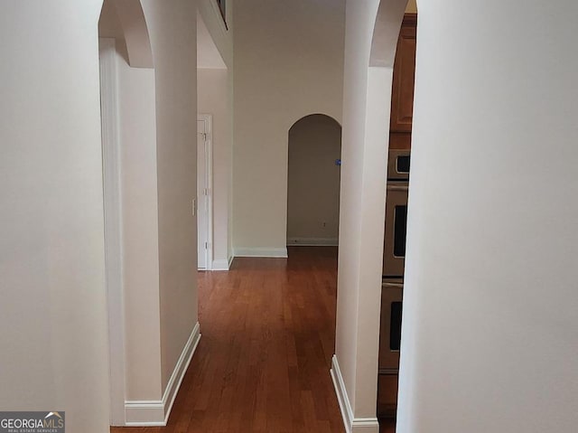 141 Windward Hls, Mcdonough, GA 30253 - hallway featuring arched walkways, dark wood-style floors, and baseboards