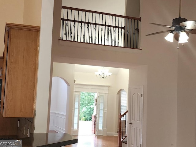 141 Windward Hls, Mcdonough, GA 30253 - foyer featuring arched walkways, ceiling fan, a chandelier, a towering ceiling, and wood finished floors