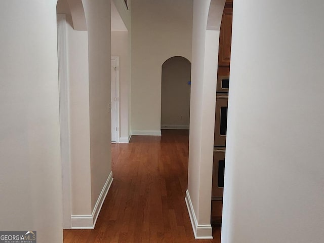 141 Windward Hls, Mcdonough, GA 30253 - hallway with arched walkways, wood finished floors, and baseboards