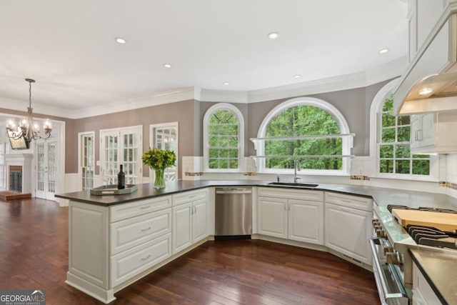 10660 Dunoon Dr, Alpharetta, GA 30022 - kitchen with stainless steel appliances, a sink, a chandelier, dark countertops, and dark wood finished floors