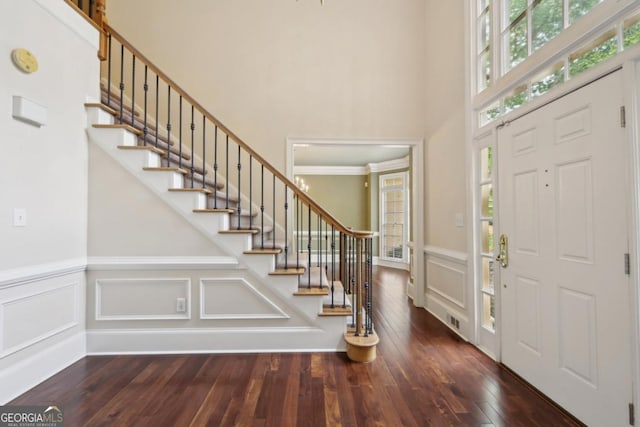 10660 Dunoon Dr, Alpharetta, GA 30022 - entryway featuring a towering ceiling, stairway, wood-type flooring, a decorative wall, and a wainscoted wall