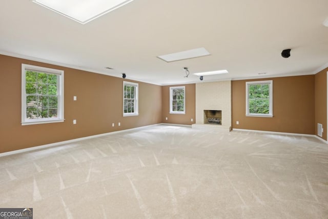 10660 Dunoon Dr, Alpharetta, GA 30022 - unfurnished living room with crown molding, baseboards, a brick fireplace, plenty of natural light, and light carpet