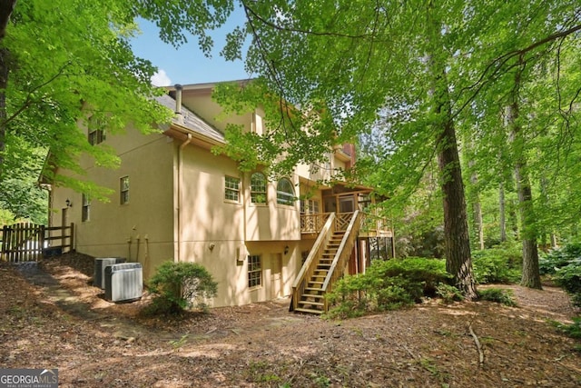 10660 Dunoon Dr, Alpharetta, GA 30022 - rear view of house featuring stairs, stucco siding, a deck, fence, and central AC