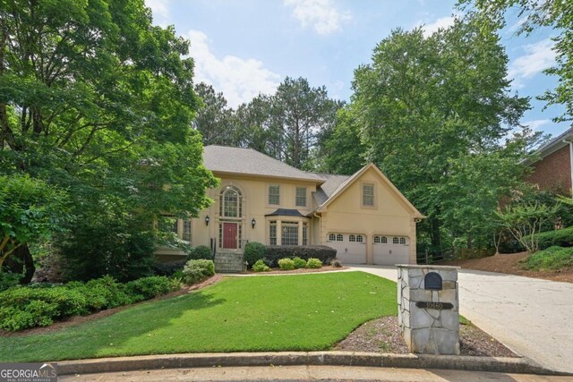 10660 Dunoon Dr, Alpharetta, GA 30022 - view of front of property with driveway, stucco siding, and a front yard