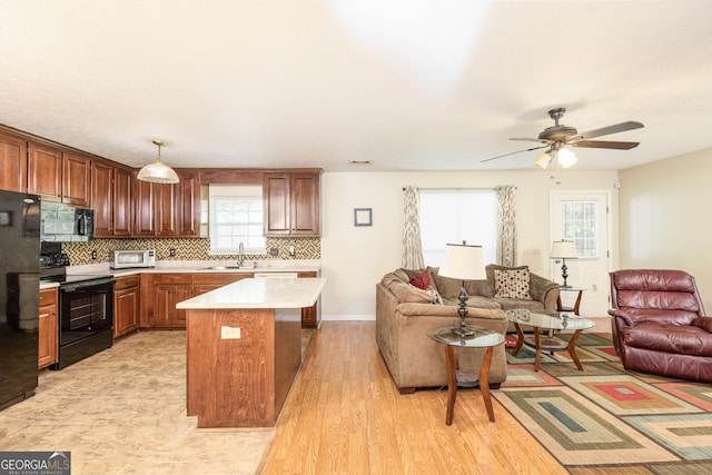 558 Wilder Dr, Columbus, GA 31907 - kitchen with black appliances, open floor plan, a sink, light countertops, and backsplash
