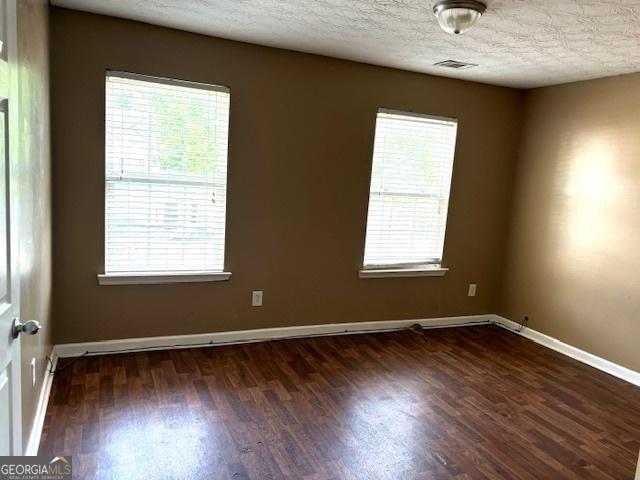 9515 Lakeview Rd, Union City, GA 30291 - empty room featuring dark wood-type flooring, a textured ceiling, and baseboards