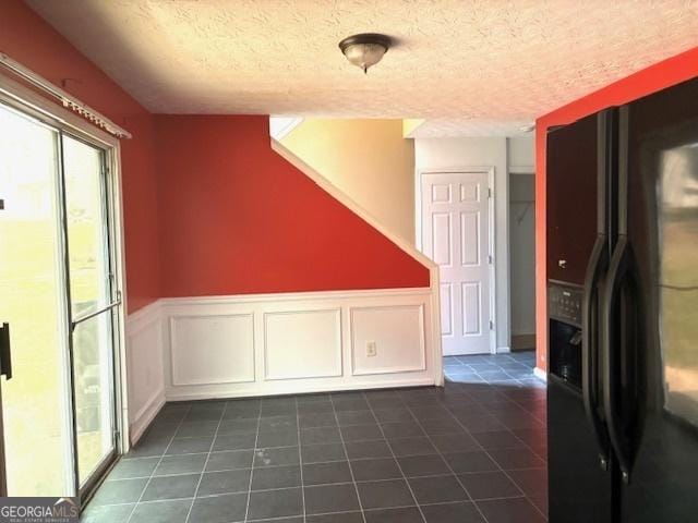 9515 Lakeview Rd, Union City, GA 30291 - unfurnished dining area with dark tile patterned flooring, healthy amount of natural light, a textured ceiling, and a wainscoted wall