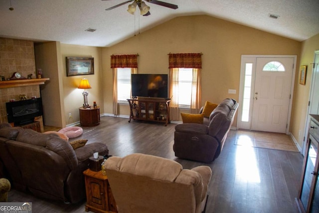 1351 Old Screven Rd, Jesup, GA 31545 - living room featuring lofted ceiling, a ceiling fan, wood finished floors, a tiled fireplace, and baseboards