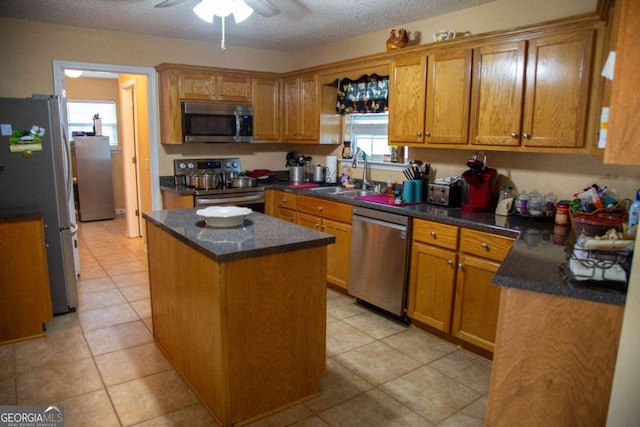 1351 Old Screven Rd, Jesup, GA 31545 - kitchen featuring stainless steel appliances, a sink, a center island, a ceiling fan, and brown cabinets