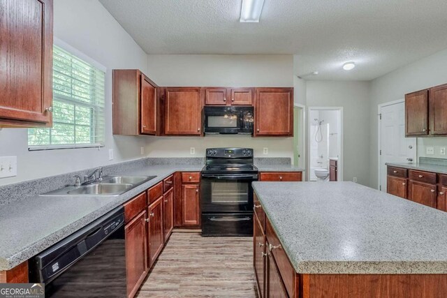 6285 Polar Fox Ct, Riverdale, GA 30296 - kitchen featuring black appliances, light wood-type flooring, a kitchen island, light countertops, and a textured ceiling