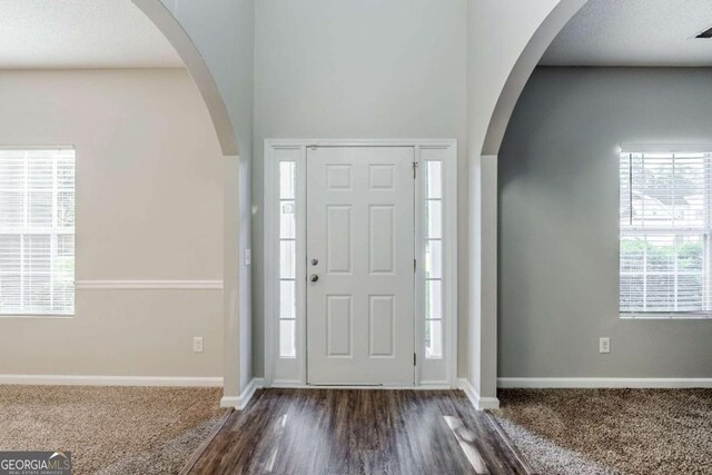 6285 Polar Fox Ct, Riverdale, GA 30296 - foyer featuring dark carpet, arched walkways, and dark wood finished floors