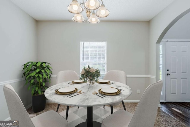 6285 Polar Fox Ct, Riverdale, GA 30296 - dining room with arched walkways, a chandelier, and wood finished floors