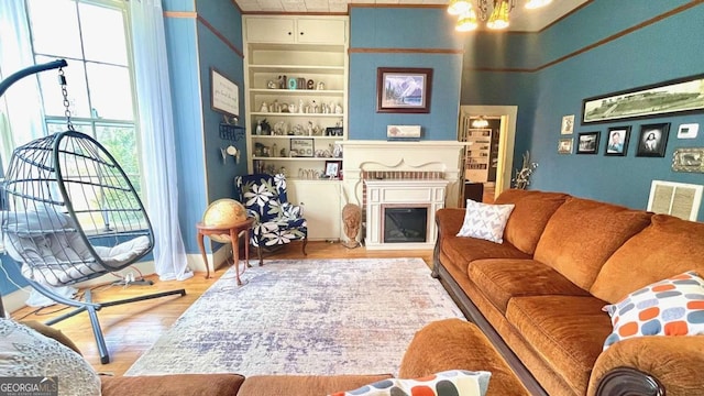 6 River St SW, Cave Spring, GA 30124 - living area with wood finished floors, a fireplace, built in shelves, and a chandelier
