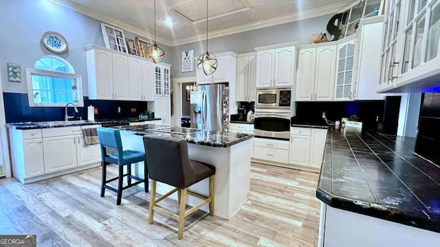 6 River St SW, Cave Spring, GA 30124 - kitchen featuring stainless steel appliances, a sink, dark countertops, a breakfast bar area, and white cabinets