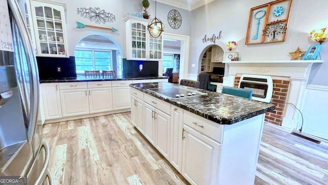 6 River St SW, Cave Spring, GA 30124 - kitchen with freestanding refrigerator, black electric stovetop, a brick fireplace, light wood-type flooring, and crown molding