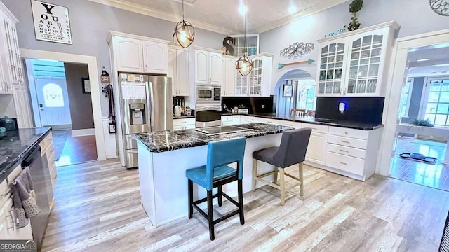 6 River St SW, Cave Spring, GA 30124 - kitchen featuring stainless steel appliances, crown molding, a breakfast bar area, arched walkways, and glass insert cabinets