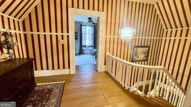 6 River St SW, Cave Spring, GA 30124 - hall featuring wallpapered walls, wood-type flooring, lofted ceiling, a chandelier, and an upstairs landing