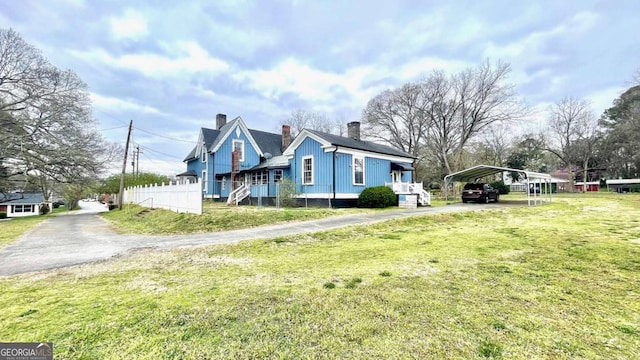 6 River St SW, Cave Spring, GA 30124 - view of home's exterior featuring asphalt driveway, a detached carport, a yard, and a chimney