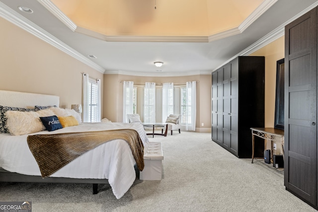 carpeted bedroom featuring ornamental molding and a tray ceiling