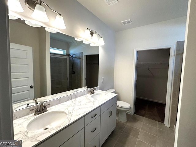 118 Garrett Dr, Eatonton, GA 31024 - full bathroom featuring a shower stall, tile patterned flooring, toilet, double vanity, and a spacious closet